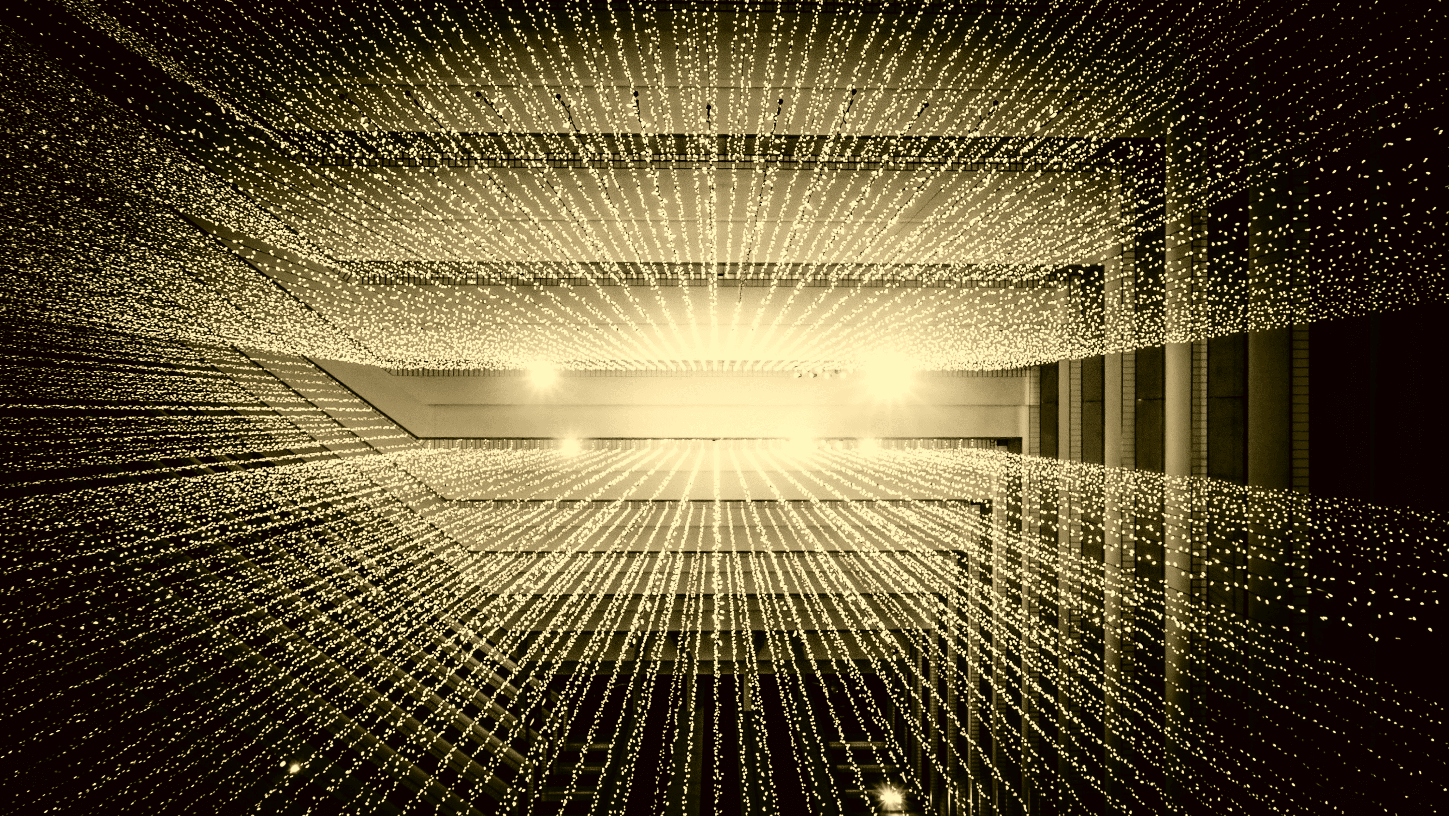Golden points of light forming an interconnected data field inside a dark architectural space