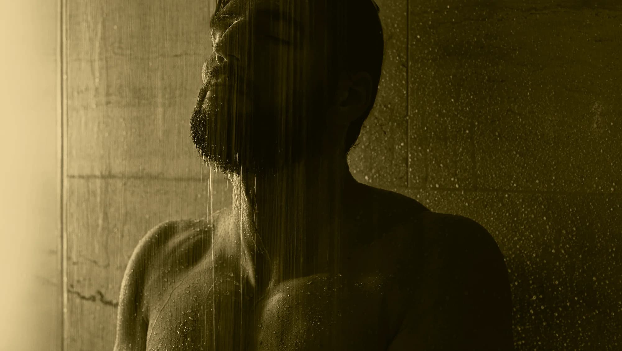 A person standing beneath a shower, representing restoration and the body’s return from stress