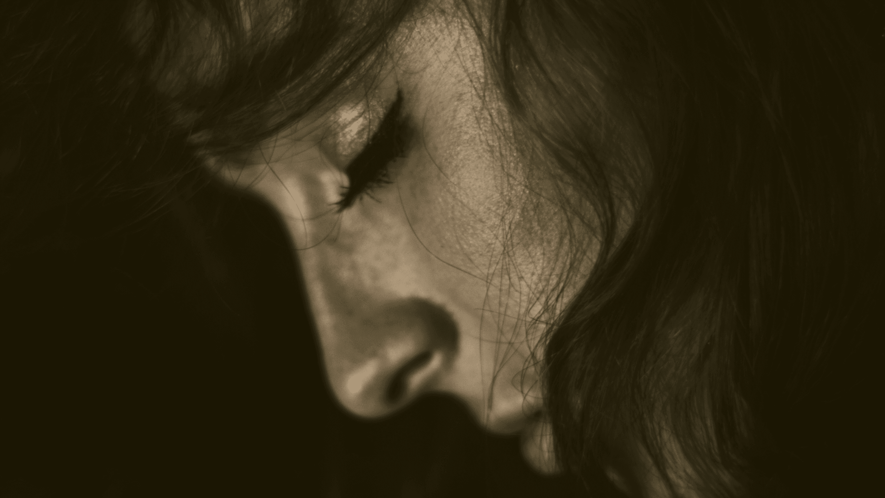 Sepia-toned close-up of a resting face, evoking sleep, restoration, and nighttime brain repair