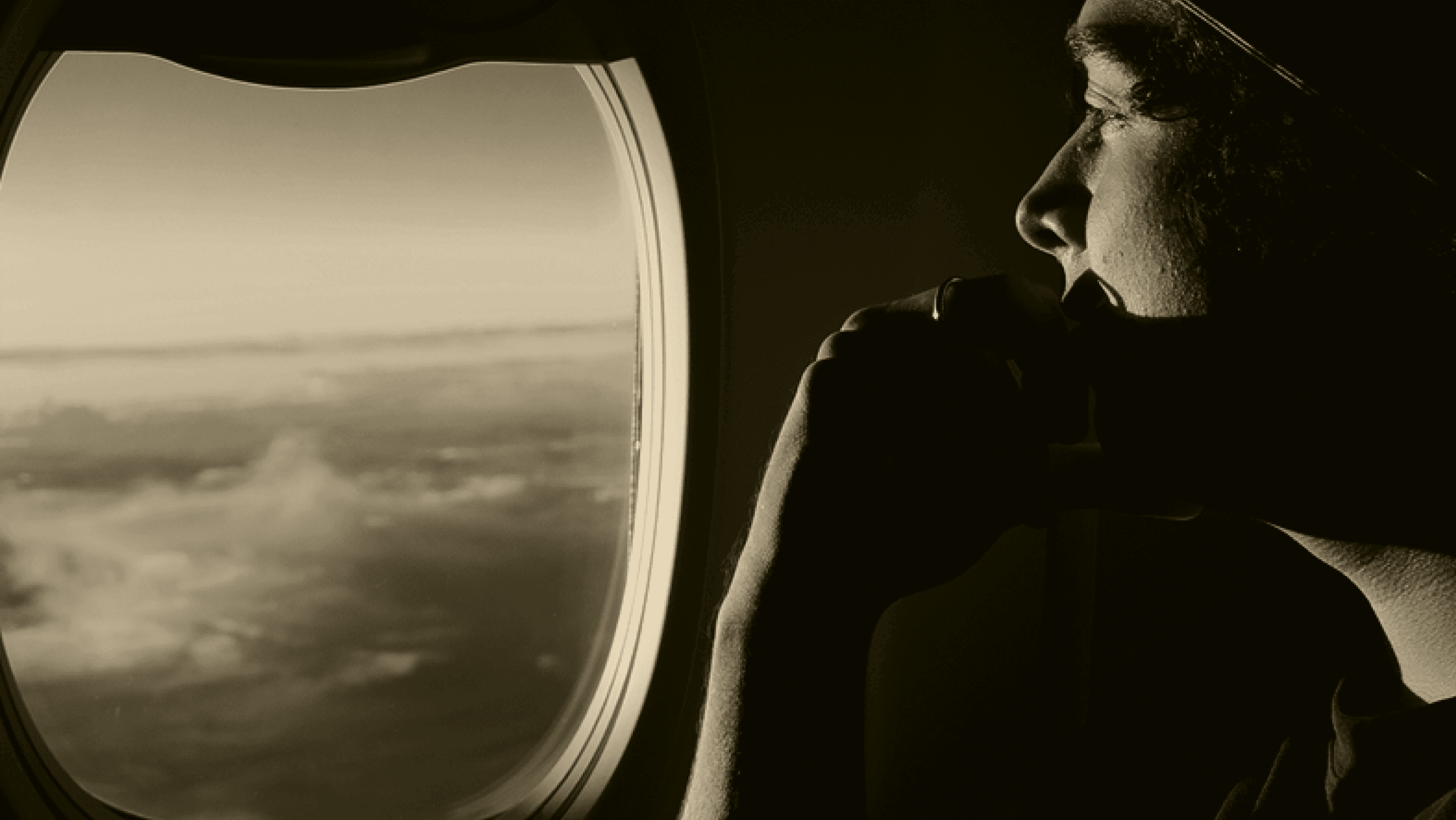 Warm editorial image of a traveler looking out an airplane window, representing healthier travel and recovery.