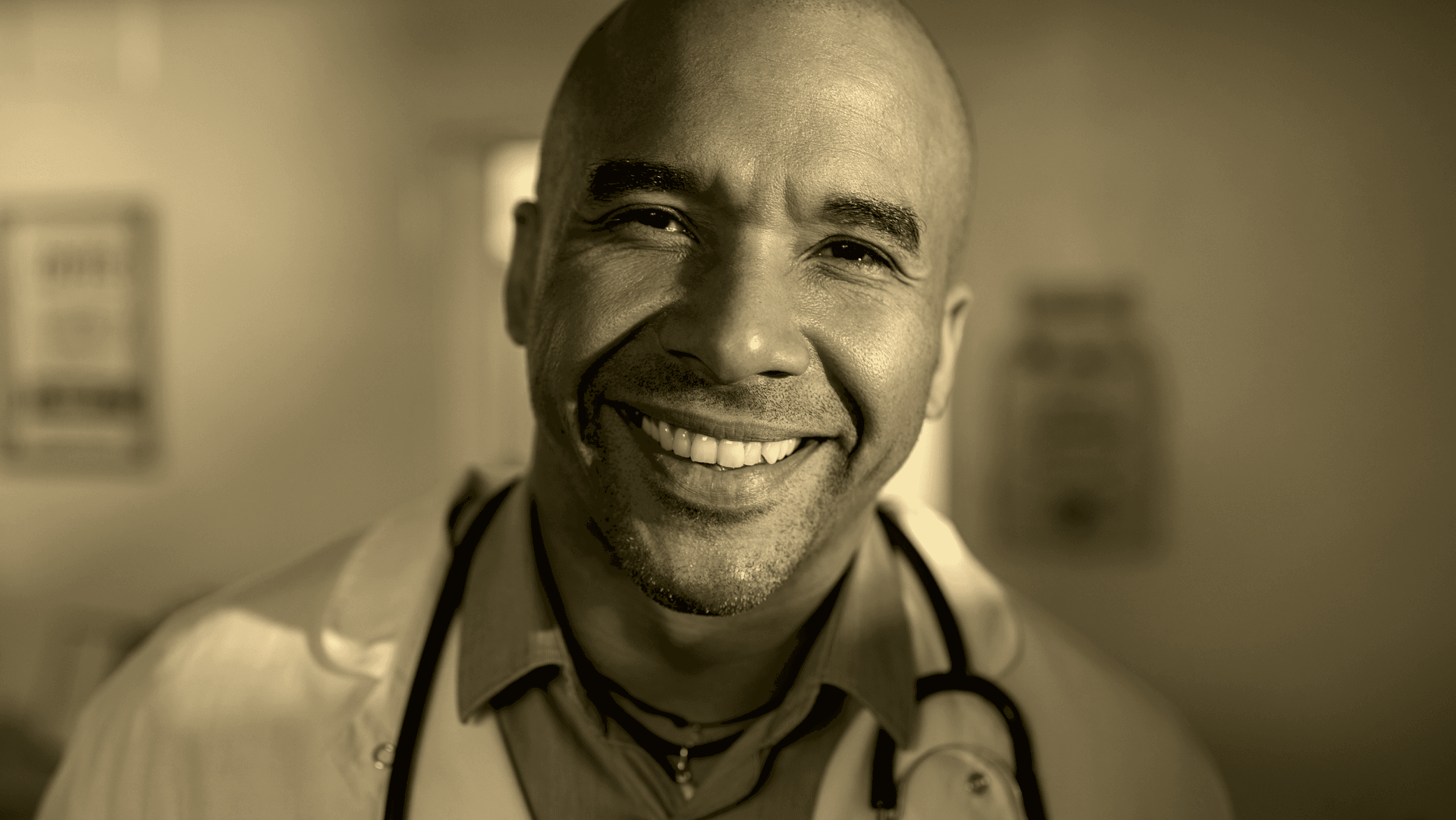 Smiling physician wearing a stethoscope in a warm monochrome clinical portrait