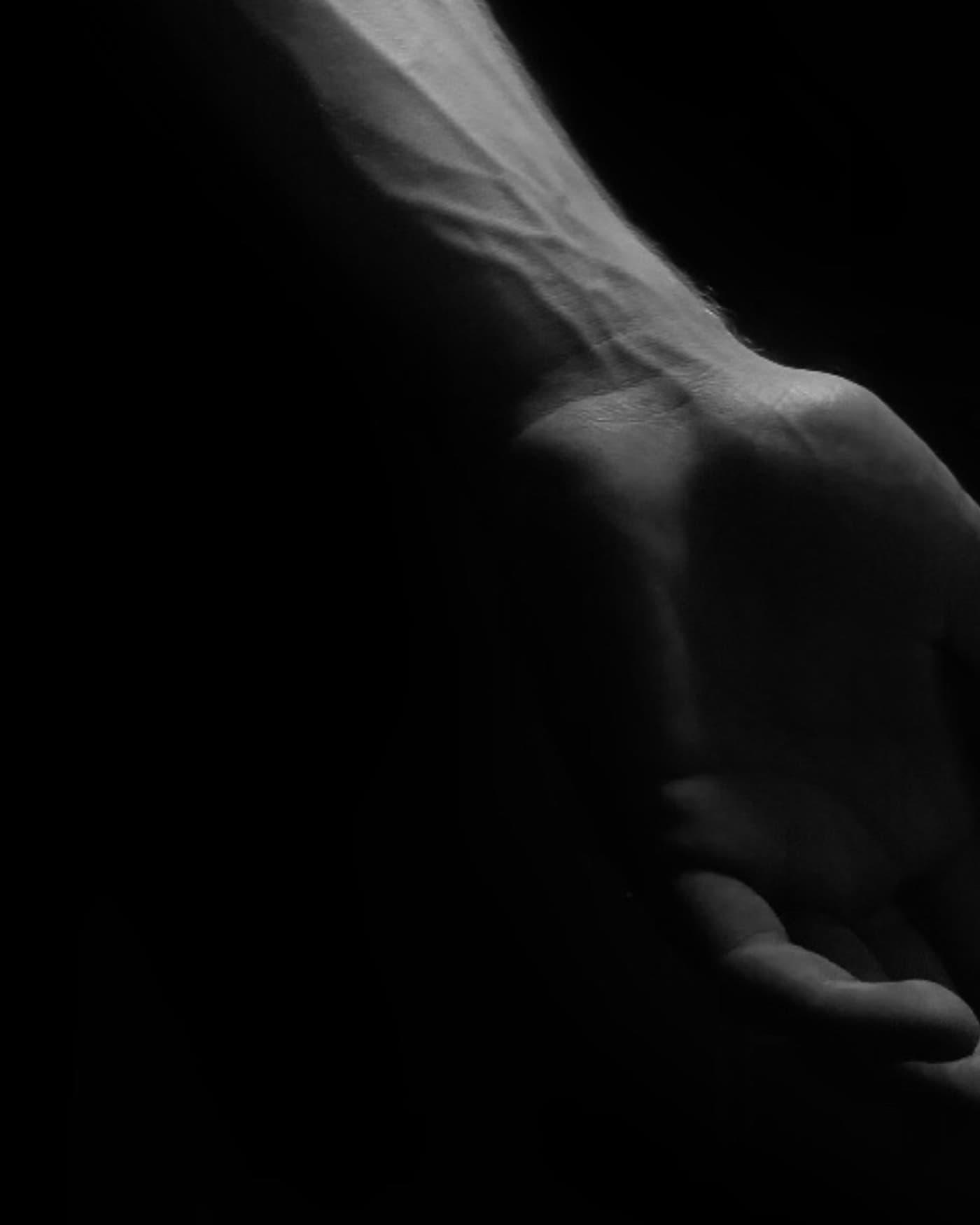 Black and white close-up of an outstretched hand and forearm